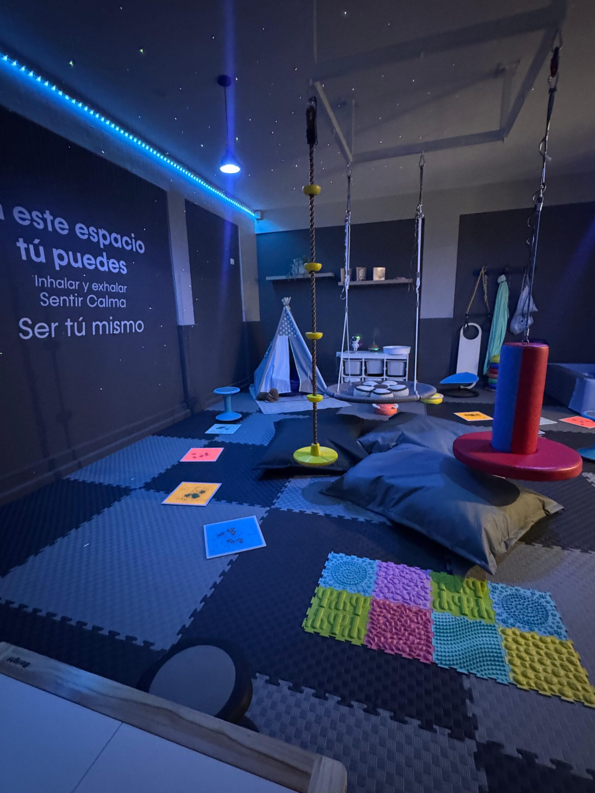 Sala sensorial con luz natural — columpio, teepee y materiales sensoriales